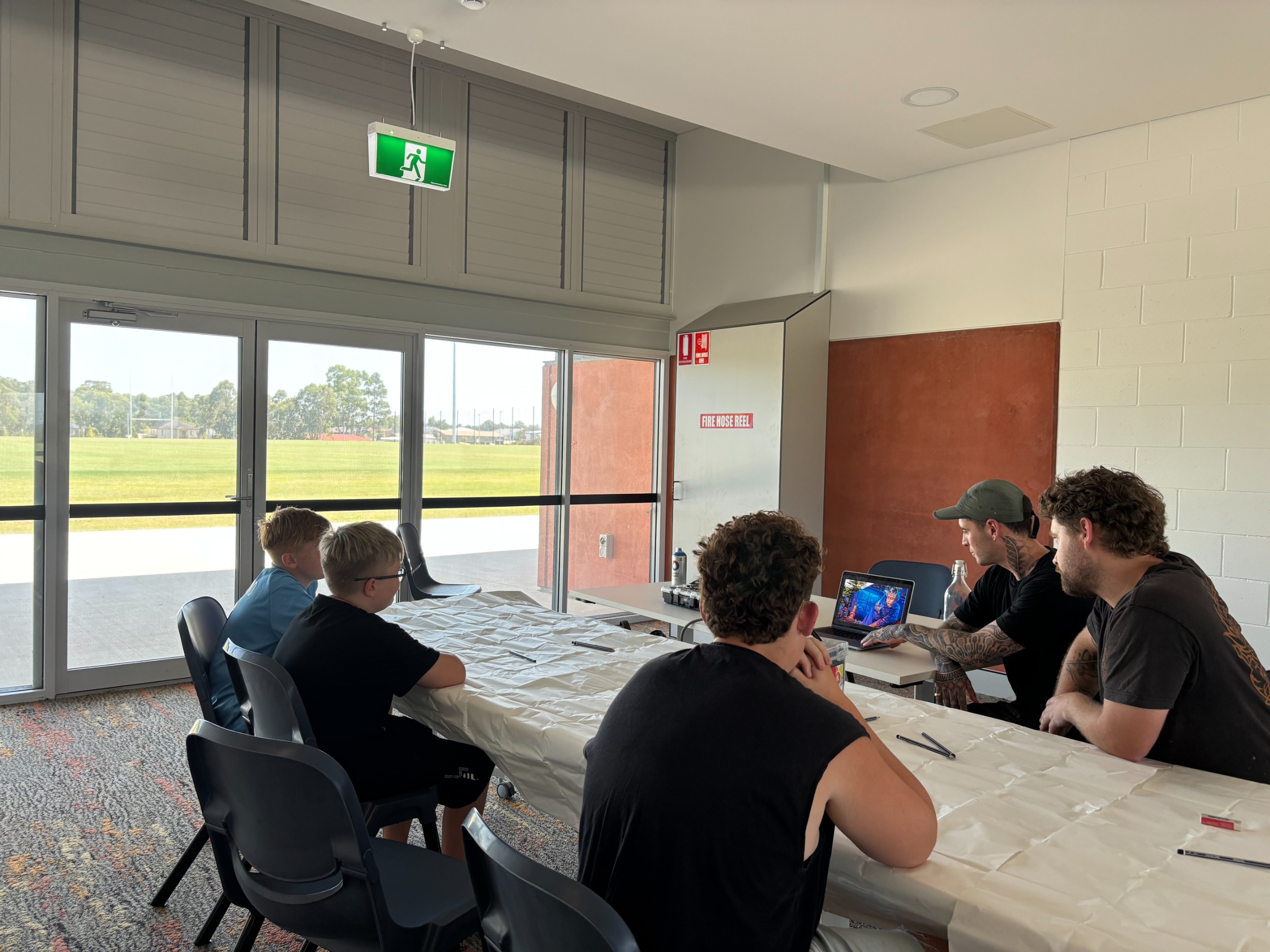 An image of young people sitting at a table brainstorming ideas