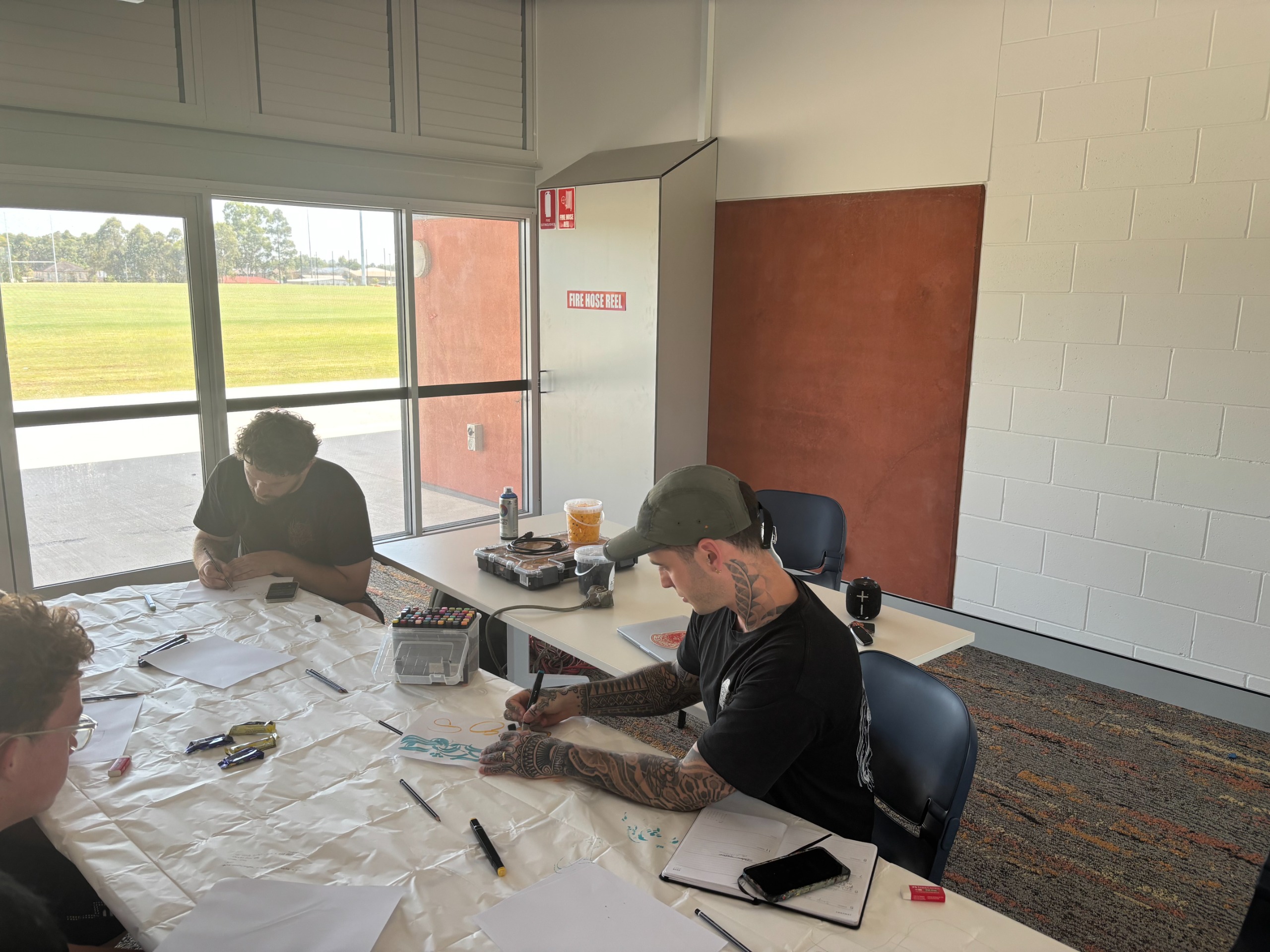 An image of young people sitting at a table brainstorming ideas