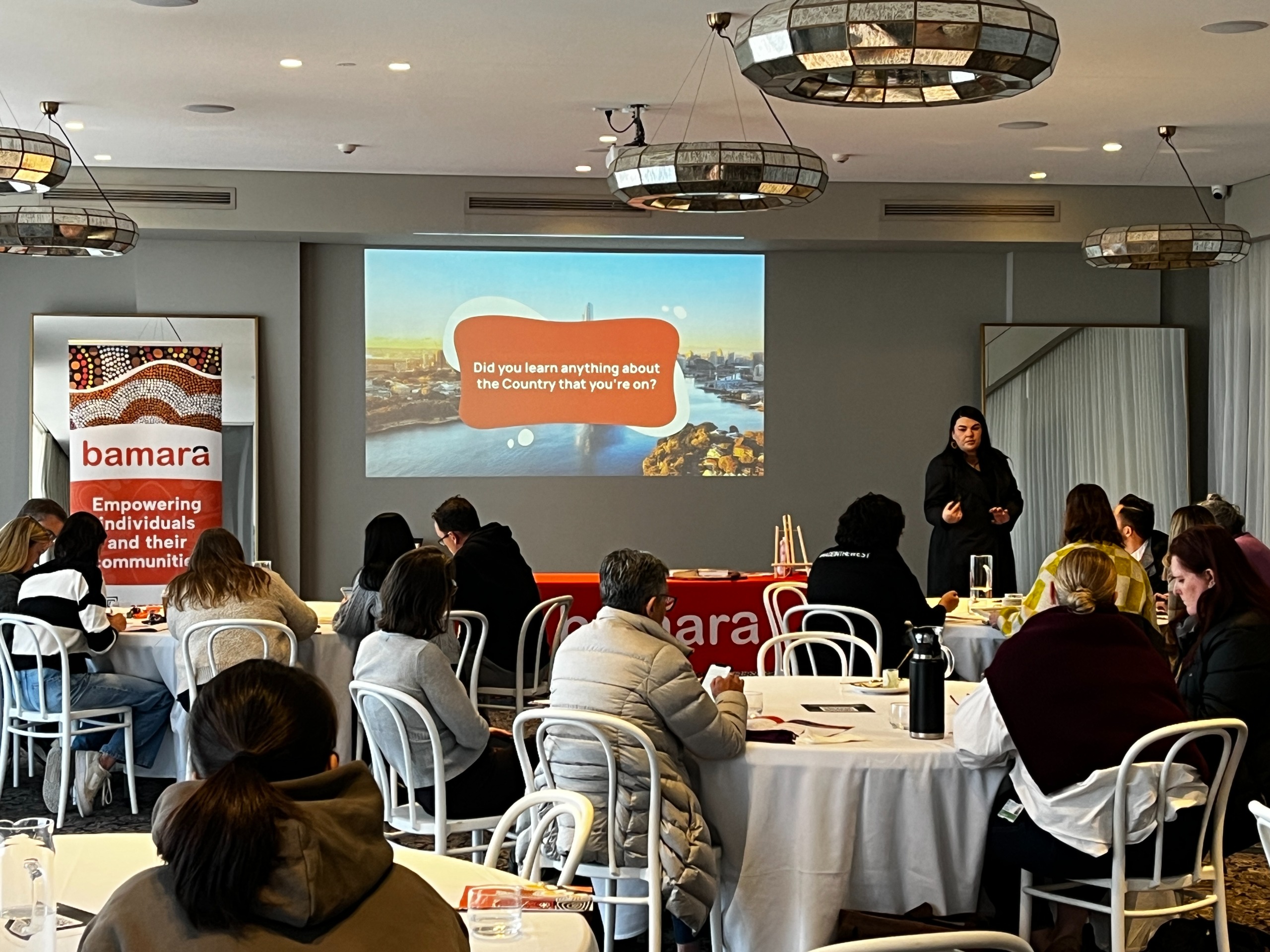 A group of people at a training session infront of a whiteboard