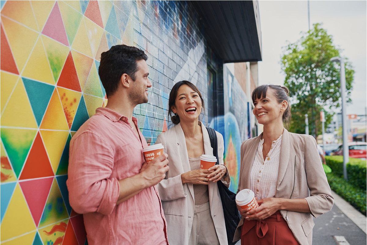 An image of a man with two women drinking coffee