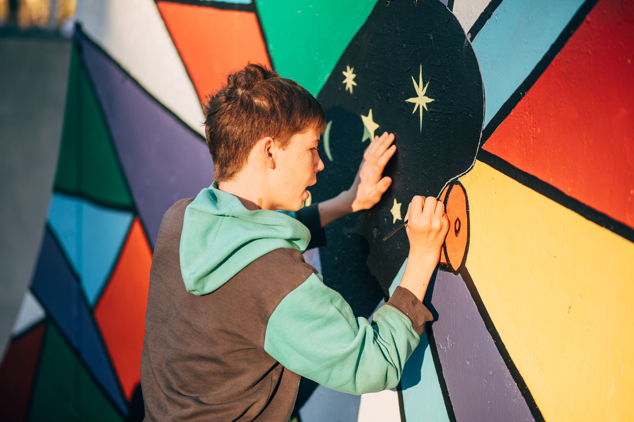 A boy painting a mural