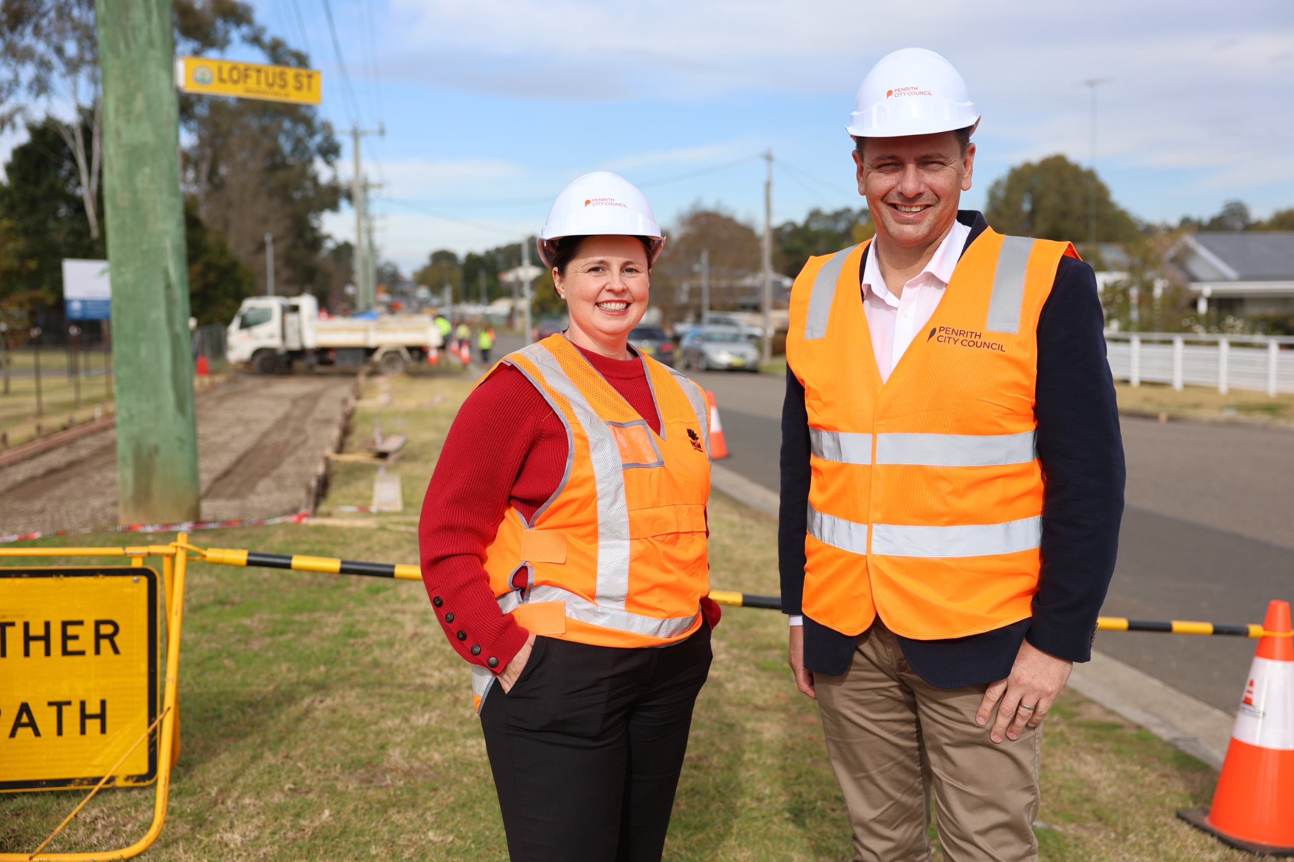 Transport for NSW’s Executive Director Cities Integration Kathryn Crestani and Penrith Mayor Todd Carney on Factory Road, at the intersection of Loftus Street, with shared path works underway in the background.